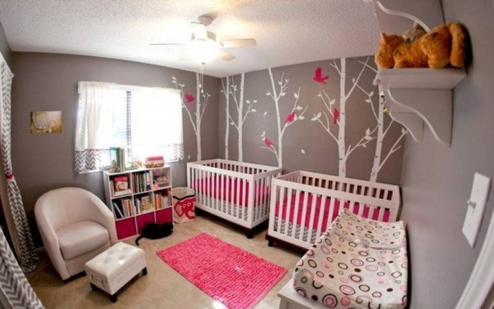 twin-baby-bedrooms-wall-decals-and-and-bookcase-and-pink-rug-and-arm-chair-with-ottoman-and-ceiling-fan-with-light-and-open-shelving