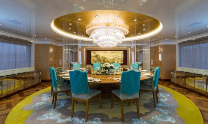 luxurious-italian-style-interior-design-in-dining-room-with-amazing-crystal-chandelier-in-white-gold-ceiling-as-well-modern-round-dining-table-plus-blue-chair-cover-and-yellow-round-rug-on-hardwood-flooring-970x581