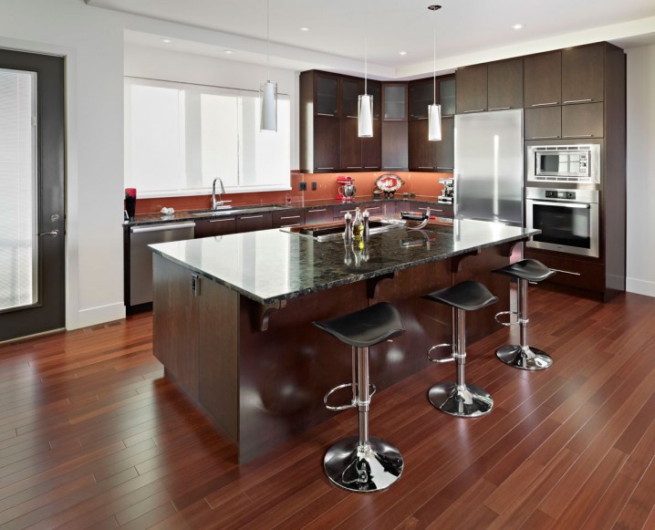 elegant-brown-kitchen-with-dark-marble-countertops-and-dark-wood-cabinets-island-also-modern-bar-stools-and-polished-wood-floors-design-ideas