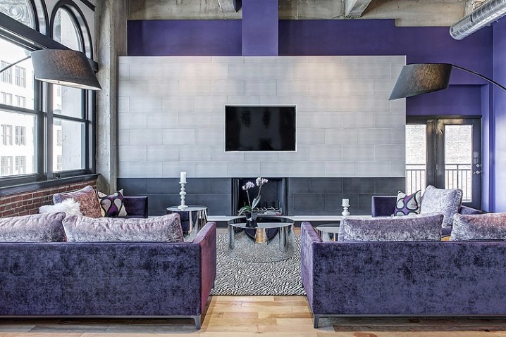 Lovely-Purple-Sofas-and-Mirrored-Round-Tables-in-Downtown-Penthouse-Loft-Sk-Interiors-Living-Room-with-Grey-Fireplace