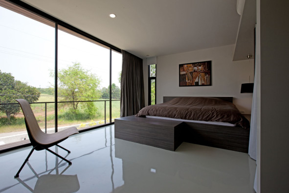 Dazzling-Floor-to-Ceiling-Windows-in-Minimalist-Bedroom-Applyig-Clear-Glass-Side-Wall-and-Sleek-Flooring-Furnished-with-Dark-Brown-King-Bed-and-Simple-Chair-591x394