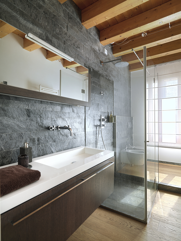 Modern bathroom with glass shower cubicle in the center