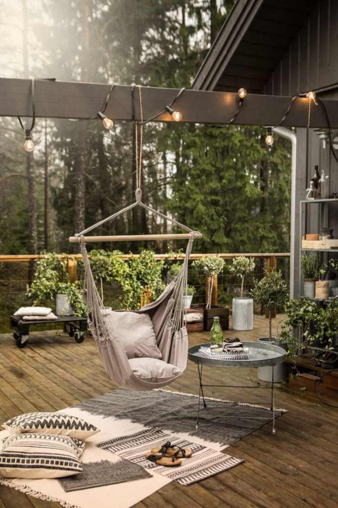 idées-déco-–aménagement-terrasse-chaise-suspendue-tapis-extérieur-coussins-sol