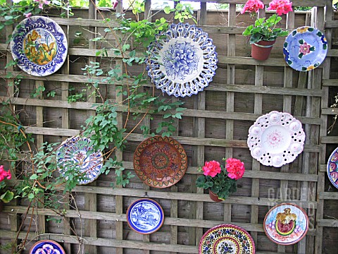 PLATES USED TO DECORATE GARDEN FENCE