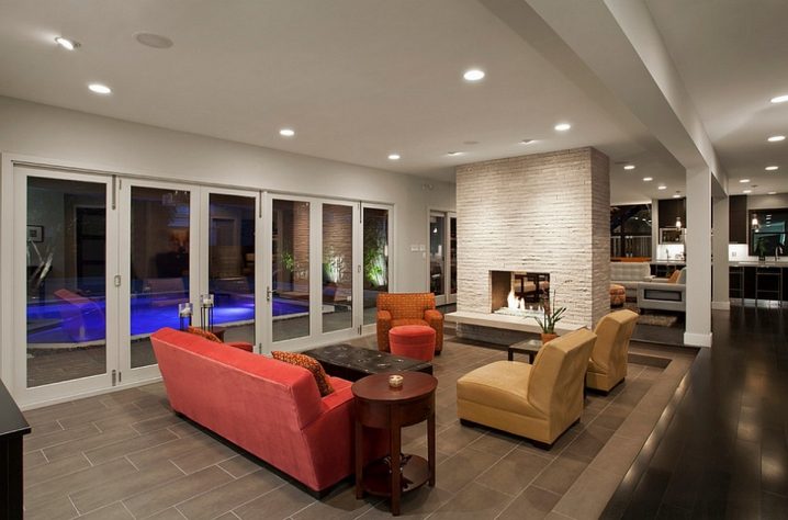 sunken-living-room-with-banquette-style-seating-and-fireplace-wall-divider-also-glass-bi-fold-retractable-door-connected-to-the-pool-outside